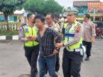 Polisi-menggandeng-dan-membawa-seorang-copet-ke-Mapolsek-Ambarawa.jpg