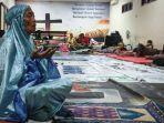 Seorang-wanita-paruh-baya-pengungsi-banjir-saat-menunaikan-salat.jpg