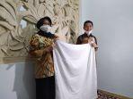 pasangan-suami-istri-asal-solo-saat-memperlihatkan-baju-ihramnya-selasa-262020.jpg