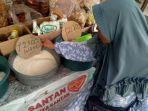 pembeli-tampak-sedang-mengambil-uang-di-dompetnya-untuk-membeli-sembako.jpg