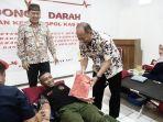 pj-bupati-pati-henggar-budi-anggoro-memberikan-bendera-merah-putih-kepada-peserta-donor-darah.jpg