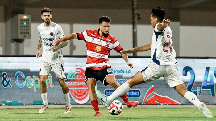 Pemain Madura United (kaus loreng merah) berebut bola dengan pemain Persita, M Toha di Stadion Gelora Madura Ratu Pamelingan, Pamekasan, Minggu (24/8/2028) malam. Laga berakhir imbang 1-1.
