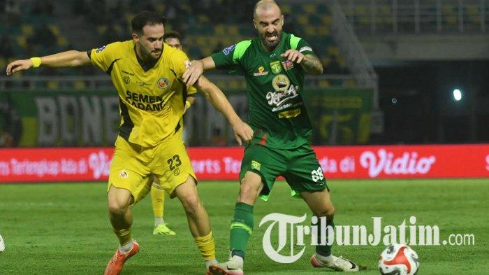LAGA - Pemain Persebaya, Milos Raickovic (kanan) berusaha melewati pemain Semen Padang FC, Rampa (kiri) pada laga lanjutan Super League 2025/2026 di Stadion Gelora Bung Tomo (GBT) Surabaya, Jumat (19/9/2025) malam. Laga Persebaya vs Semen Padang berakhir dengan skor 1-0 untuk kemenangan Bajul Ijo.