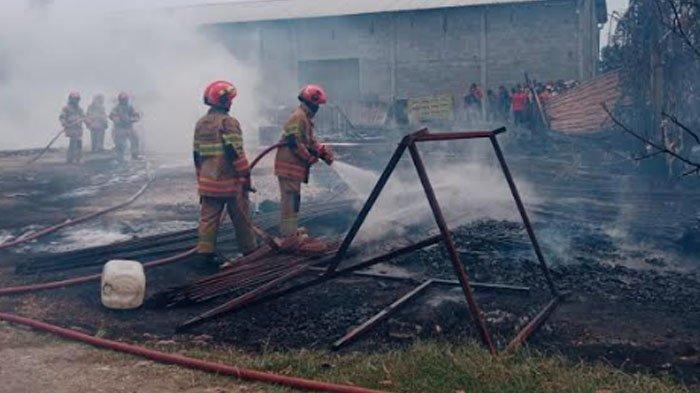 PEMBASAHAN - Petugas Damkarmat Bojonegoro saat melakukan pembasahan di gudang penyimpanan solar di Desa Bulaklo, Kecamatan Balen, Kabupaten Bojonegoro, Jawa Timur, yang dilalap api pada Selasa (6/1/2026). Api diduga dipicu korsleting listrik.