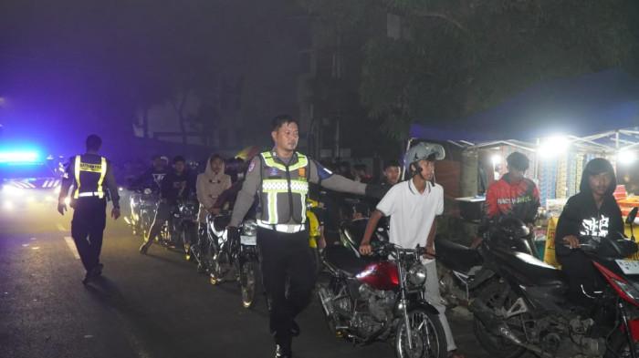 DIAMANKAN: Petugas kepolisian Polres Malang mengamankan kendaraan yang terlibat balap liar di depan Stadion Kanjuruhan, Sabtu (22/11/2025) dini hari.