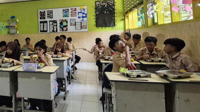 KONSUMSI MBG - Siswa SMP Negeri 2 Kota Malang saat menyantap hidangan MBG pada Kamis (2/10/2025) lalu. Diketahui, SPPG yang memasok MBG di sekolah tersebut ditutup sementara sehingga siswa SMP Negeri 2 Kota Malang diimbau untuk membawa bekal makan dari rumah
