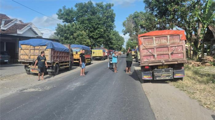 DIHENTIKAN - Warga saat menghentikan dump truk yang beroperasi di Jalan Ponorogo-Jenangan, Desa Jimbe, Kecamatan Jenangan, Kabupaten Ponorogo, Jatim untuk sopirnya dimintai audiensi, Selasa (24/7/2025). Puluhan dump truk bermuatan tambang pasir diberhentikan oleh warga di Jalan Rata Ponorogo-Jenangan, Desa Jimbe, Kecamatan Jenangan, Kabupaten Ponorogo, Jatim, Selasa (29/7/2025).