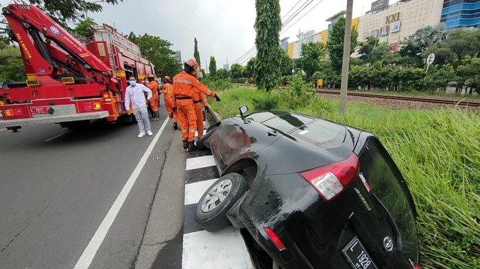 Sopir Ngantuk, Mobil Terperosok Parit di Frontage A Yani Surabaya