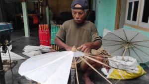 Asbani-70-sedang-memproduksi-kerajinan-payung-kertas-di-teras-rumahnya.jpg