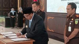 Bupati-Jombang-Warsubi-saat-menandatangani-nota-kesepahaman-MoU-terkait-penanganan-laporan.jpg