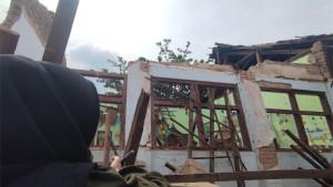 Seorang-warga-tengah-menengok-kondisi-ruang-kelas-4-di-SDN-II-Jatigreges.jpg