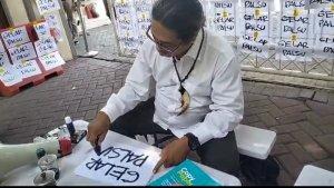 Taufik-Monyong-melakukan-aksi-teatrikal-untuk-menyoroti-kasus-gelar-palsu.jpg