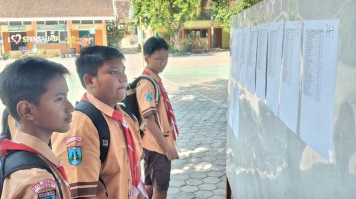 Para-murid-baru-di-SMPN-1-Mejayan-melihat-daftar-nama-peserta-didik-yang-terpasang-di-papan-sekolah.jpg