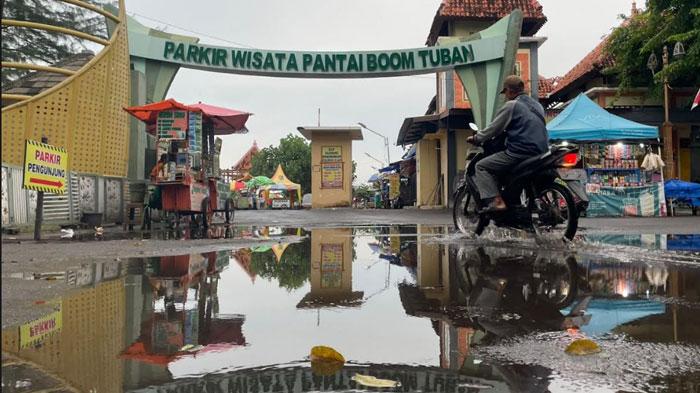 Pemotor-melintas-di-genangan-air-usai-hujan-di-kawasan-parkir-wisata-Pantai-Boom.jpg