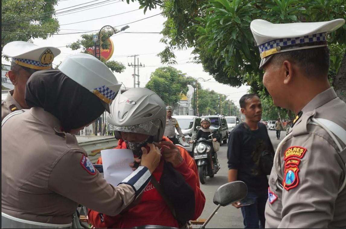 Pihak-kepolisian-dari-Satlantas-Polres-Jombang-saat-memberikan-helm.jpg