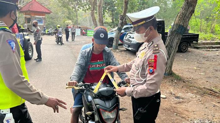 Polisi-memberikan-janur-kuning-kepada-pelanggar-lalu-lintas-di-Kabupaten-Jember.jpg