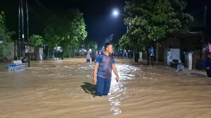 Seorang-warga-tengah-berjalan-melintasi-banjir-di-Madiun.jpg