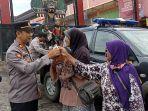 Anggota-Polsek-Pulung-membagikan-ikan-cupang-di-perempatan-pasar-Pulun.jpg