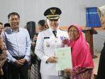 Bupati-Mojokerto-Ikfina-Fahmawati-menyerahkan-simbolis-Sertifikat-Hak-Atas-Tanah-SHAT.jpg