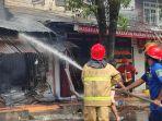 Petugas-pemadam-kebakaran-berusaha-memadamkan-api-di-kios.jpg
