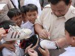 Prabowo-Subianto-membubuhkan-tanda-tangan-di-sepatu-siswa-SD.jpg
