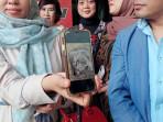 SAJADAH-DIBAKAR-Istri-Yai-Mim-Rosida-Vignesvari-saat-menunjukkan-foto-dokumentasi-kondisi-sajadah.jpg