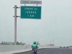 Screenshot-pemotor-beratribut-ojol-saat-melenggang-di-ruas-Tol-Juanda.jpg