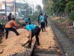 Sejumlah-petugas-Kereta-Api-membersihkan-tumpahan-biji-jagung-di-rel-kereta-api.jpg