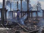 Seorang-berdiri-di-tengah-puing-kandang-ayam-di-Blitar-yang-terbakar.jpg