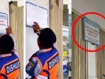 Seorang-yang-diduga-petugas-Dishub-menghapus-tulisan-Parkir-Gratis-di-sebuah-minimarket.jpg