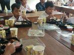 Siswa-SD-menyantap-makan-siang-gratis-yang-disiapkan-ibu-ibu-PKK.jpg