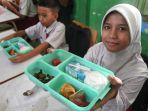 Siswa-menunjukan-menu-saat-pelaksanaan-program-Makan-Bergizi-Gratis-MBG.jpg