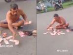 aksi-pria-sebarkan-uang-Rp100-ribu-di-tengah-jalan.jpg