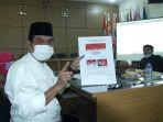 cabup-gresik-mohammad-qosim-menunjukkan-desain-surat-suara-yang-bakal-digunakan.jpg
