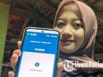 ilustrasi-urus-adminduk-online-Warga-menunjukkan-aplikasi-Si-Apel-yang-dikelola-Disdukcapil-Malang.jpg