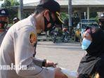 kapolres-nganjuk-akbp-handono-subiakto-saat-membagikan-paket-bantuan-beras.jpg