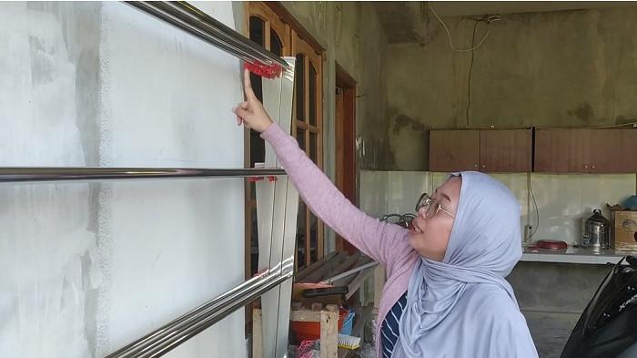 TITIK API: Laila Putri Rahma Dewi, tetangga sebelah utara rumah Agusyani menunjukkan lokasi di mana handuk diletakkan semampir di tempat jemuran sebelum akhirnya terbakar, jumat (5/6) dini hari.