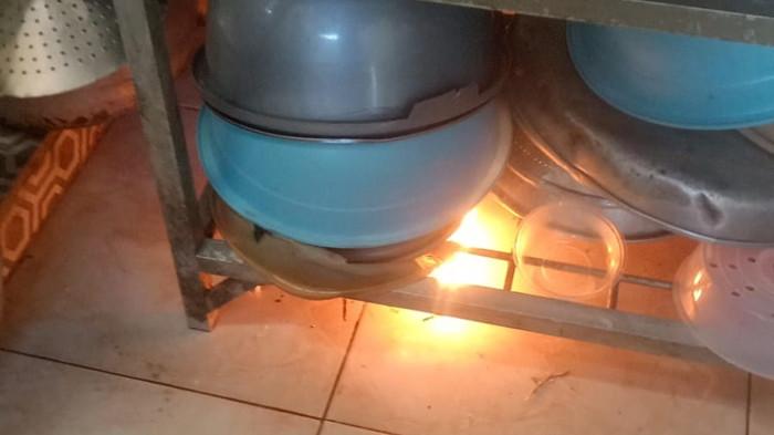 API MISTERIUS - Titik api menyala lagi, membakar baskom plastik di bawah rak piring di dapur Rumah Agus Yani di Kasuran, Margomulyo, Seyegan, Sleman Jumat (29/5/2026) siang.