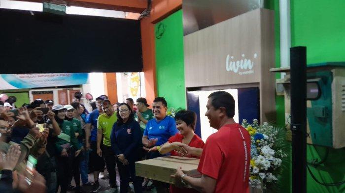 Branch Manager Bank Mandiri KCP Yogyakarta Diponegoro, Sugeng, dan Kepala Dinas Perdagangan Kota Yogyakarta, Veronica Ambar Ismuwardani, secara simbolis memotong pita dalam penyerahan bantuan digitalisasi di Pasar Kranggan, Kota Yogyakarta, DIY, Sabtu (25/10/2025).