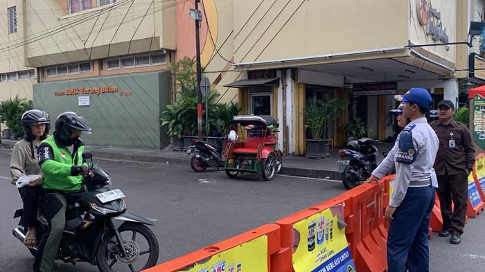 FULL PEDESTRIAN - Petugas Dinas Perhubungan mengawasi arus kendaraan di salah satu jalan sirip Malioboro saat uji coba kebijakan full pedestrian, Senin (1/12/2025). Ruas pendukung ini menjadi titik yang kerap menimbulkan pelanggaran pola lalu lintas
