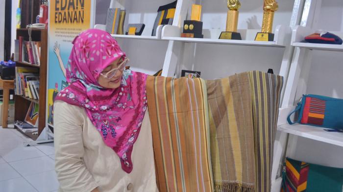 Dyah tengah menunjukkan kain tenun pewarna alam yang sedang diproduksi LAWE, Rabu (19/11/2025).