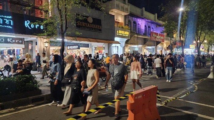 FUL PEDESTRIAN: Wisatawan menikmati atmosfer skema full pedestrian yang diterapkan di kawasan Malioboro sepanjang malam tahun baru, Rabu (31/12/25).
