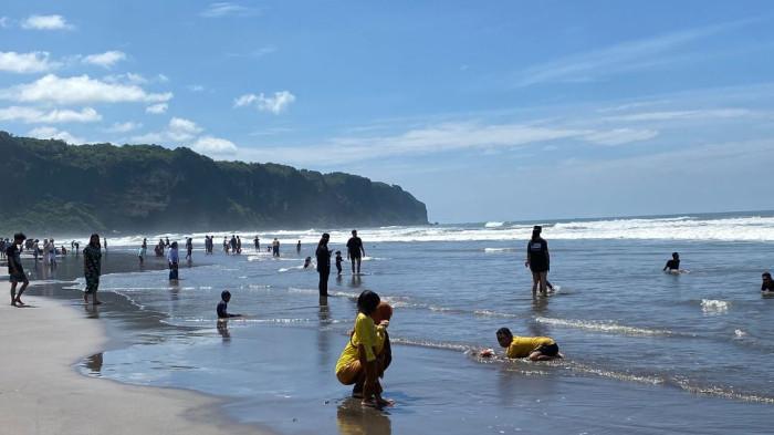 PADUSAN : Sejumlah wisatawan sedang bermain air di Pantai Parangtritis, Kabupaten Bantul, DI Yogyakarta, Senin (16/2/2026).