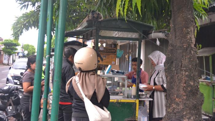 Eva dan karyawan tengah melayani pembeli di lapak Djadjanan Pak Darso cabang depan Pasar Lempuyangan, Yogyakarta, Minggu (16/11/2025).