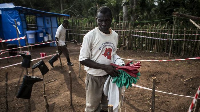 Seorang petugas kesehatan membersihkan perlengkapannya ketika ebola mewabah pada Juni 2017. 