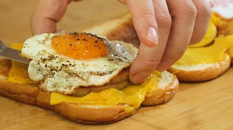 Buka-roti-tawar-yang-sudah-dipanggang-lalu-letakkan-tumpukan-ham-dan-telur-ceplok-di-dalamnya.jpg