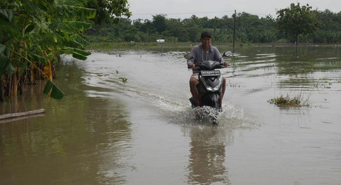 pengendara-sepeda-motor-menerobos-banjir-yang-melanda-Desa-Bener-Klaten.jpg