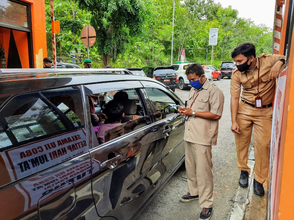 petugas-saat-mendata-pengunjung-di-pintu-retribusi-baron.jpg