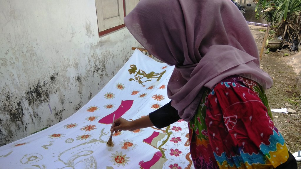 sumarni-alisha-aprilisa-sedang-menggoreskan-kuas-sabut-kelapa-pada-kain-batik-di-rumahnya.jpg