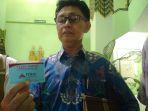 lukas-mulyono-ketua-ii-ppmay-menunjukkan-kartu-pas.jpg